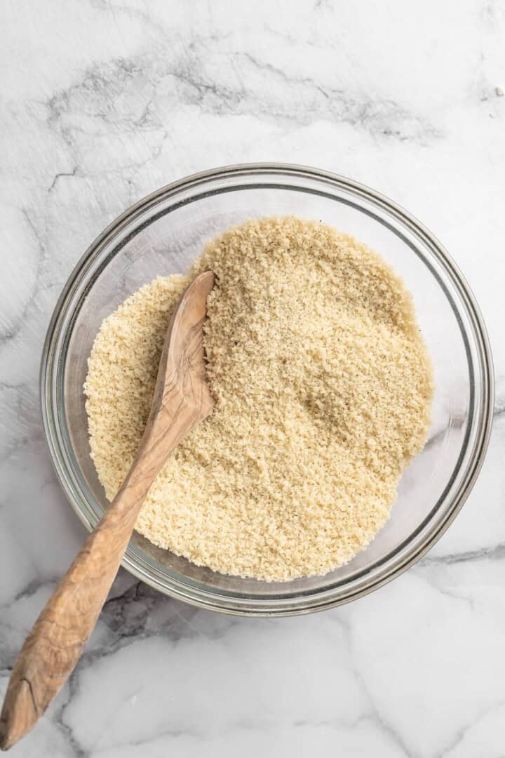 These Cauliflower Bites are crispy, crunchy and full of big flavour thanks to an irresistible sweet sriracha sauce. A total crowd pleaser! Overhead view of breadcrumbs in bowl with wooden spoon