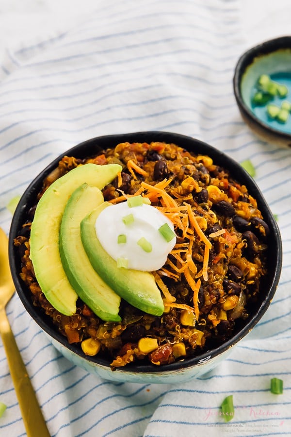 Vegan crockpot chili in a bowl topped with slices of avocado. 