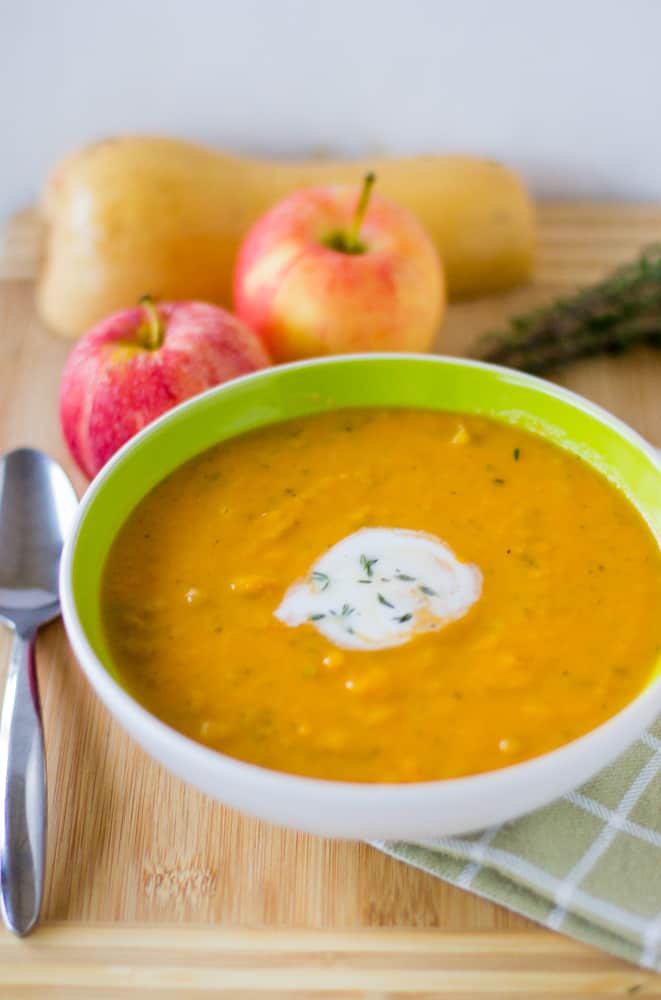A green bowl full of apple and butternut squash soup. 