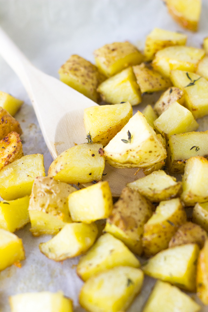 Close up of garlic butter roasted potatoes on parchment. 