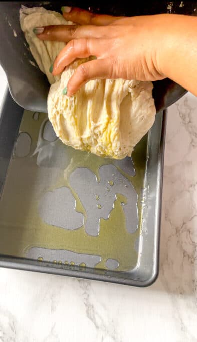 pouring dough into an oiled baking pan