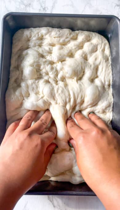 fingers dimpling bread dough