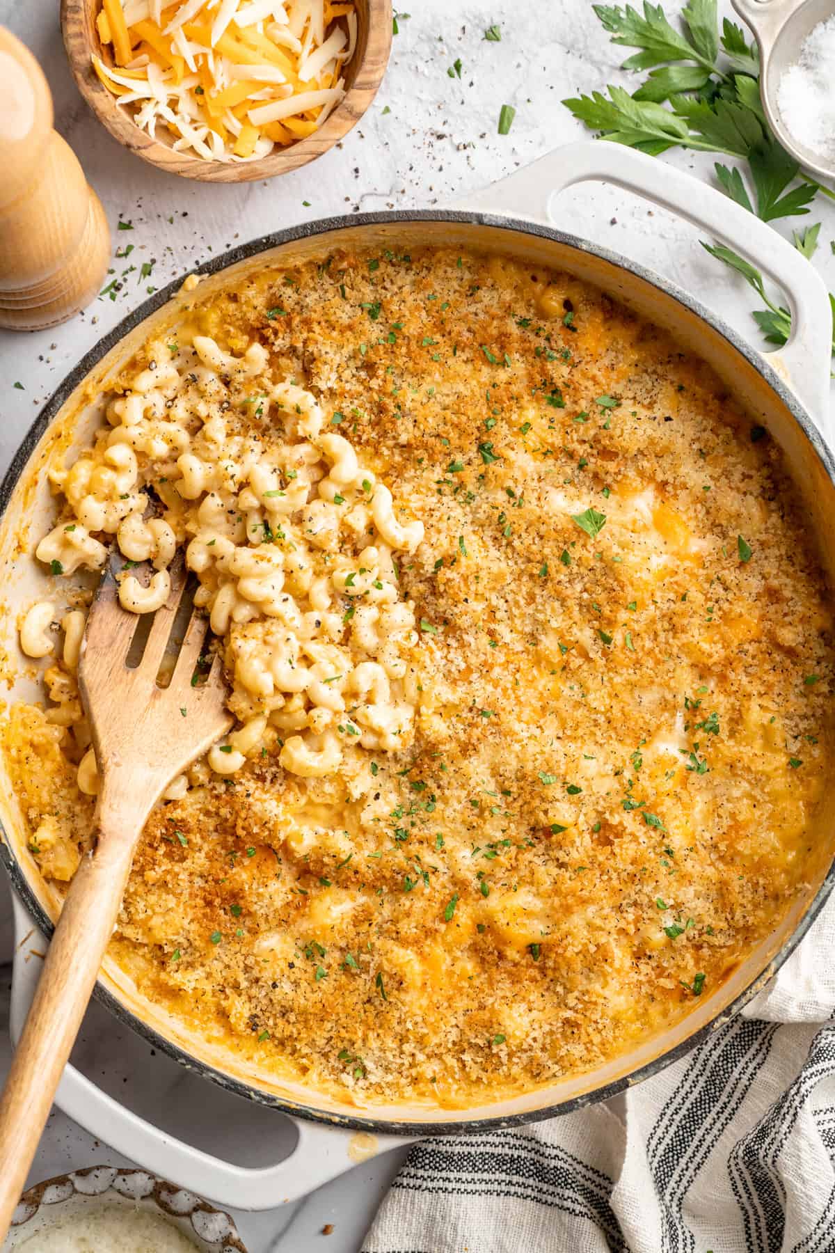 Wooden spatula scooping vegan mac and cheese from skillet.