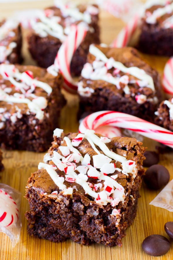 Chocolate brownies with crushed candy cane toppings, on a wood table. 