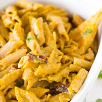 Overhead shot of penne pasta in a white baking dish