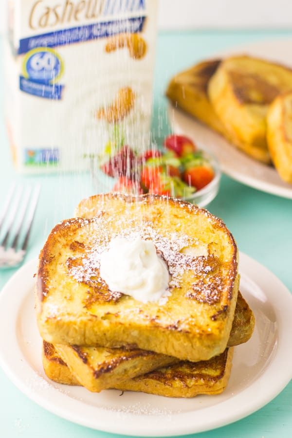 Sprinkling confectioner's sugar on french toast.