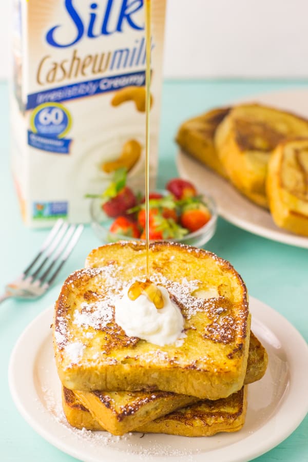 A stack of eggnog french toast with syrup poured onto it. 