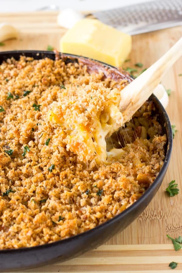  Baked macaroni and cheese in a skillet with a wooden spoon.