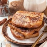 Stack of 3 slices of eggnog French toast on plate.