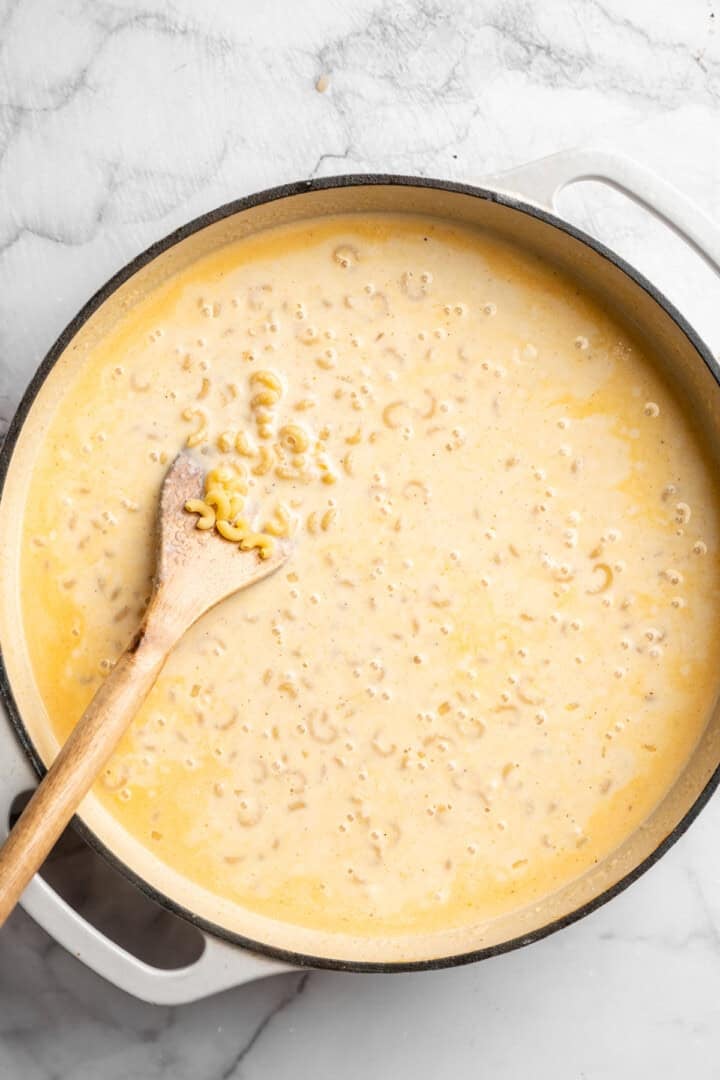 Pasta simmering in skillet of vegan cream sauce.