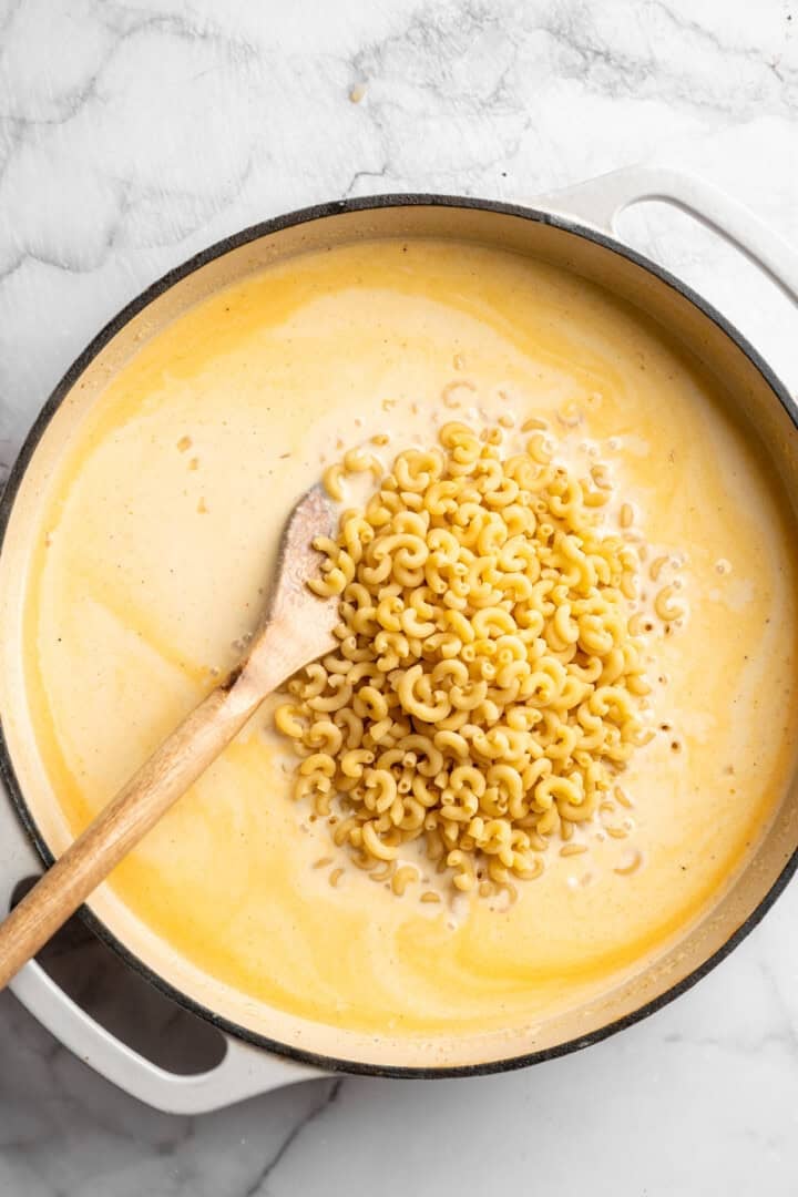 Stirring pasta into vegan cream sauce.