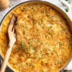 Wooden spatula digging into skillet of 3 cheese vegan mac and cheese.