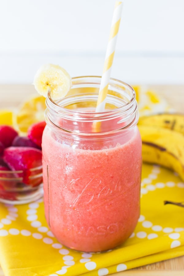 Strawberry banana smoothie in a mason jar with a straw. 