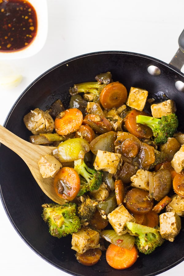 Overhead shot of tofu stir fry in a black skillet. 