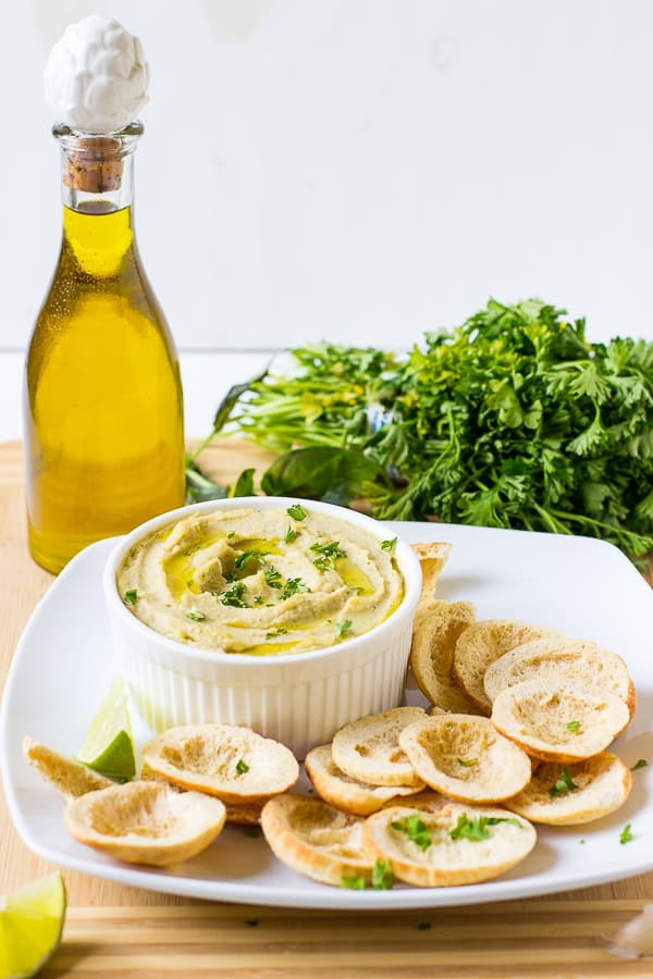 Side shot of herbed roasted garlic white bean dip in a ramekin. 