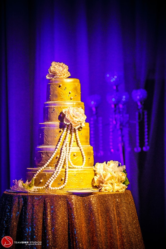 Side shot of gold wedding cake. 