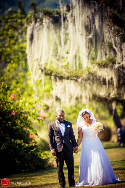 Jessica and gavin holding hands under a tree.