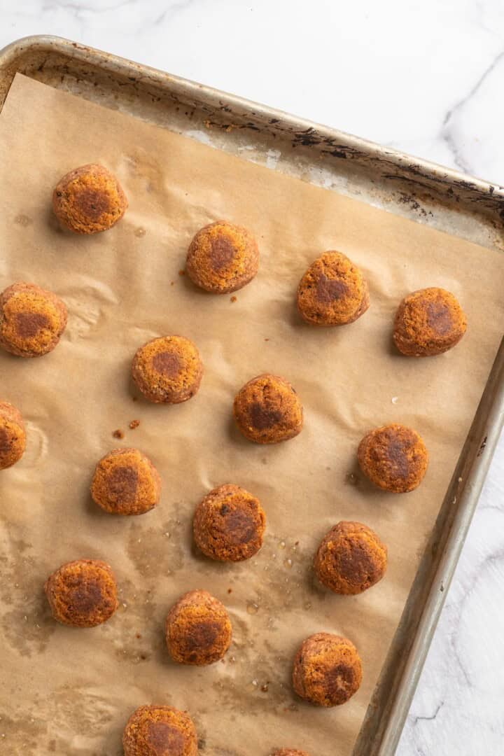 Overhead view of chickpea and beet vegetarian meatballs on baking sheet
