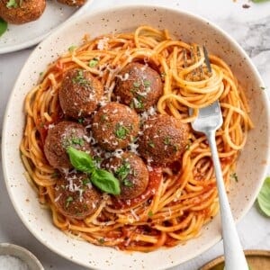 Overhead view of chickpea and beet vegetarian meatballs in bowl of spaghetti