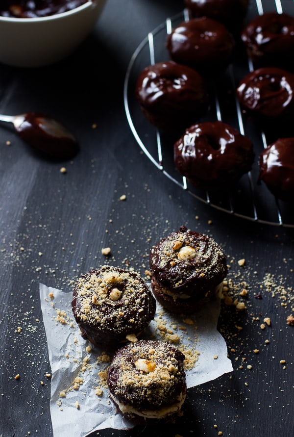 Overhead shot of baked chocolate cake s'mores donuts on parchment.