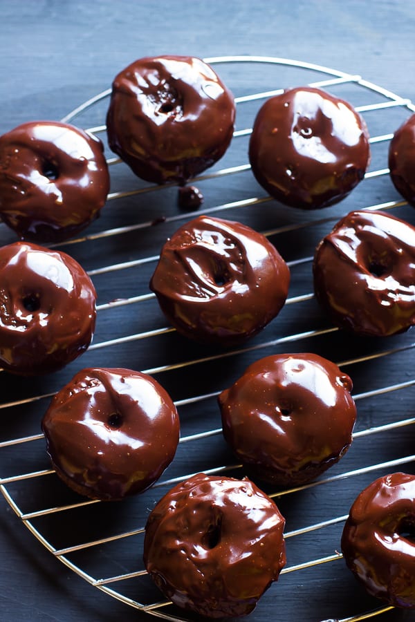 Top down shot of chocolate donuts on a wire rack. 