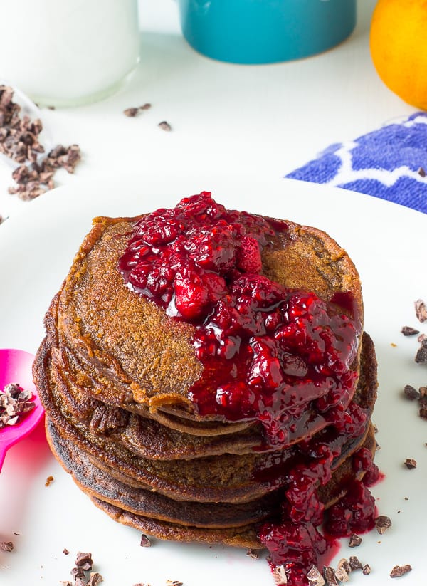 Overhead shot of chocolate peanut butter pancakes with berry compete on top.