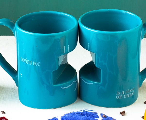 Two blue mugs on a table. 