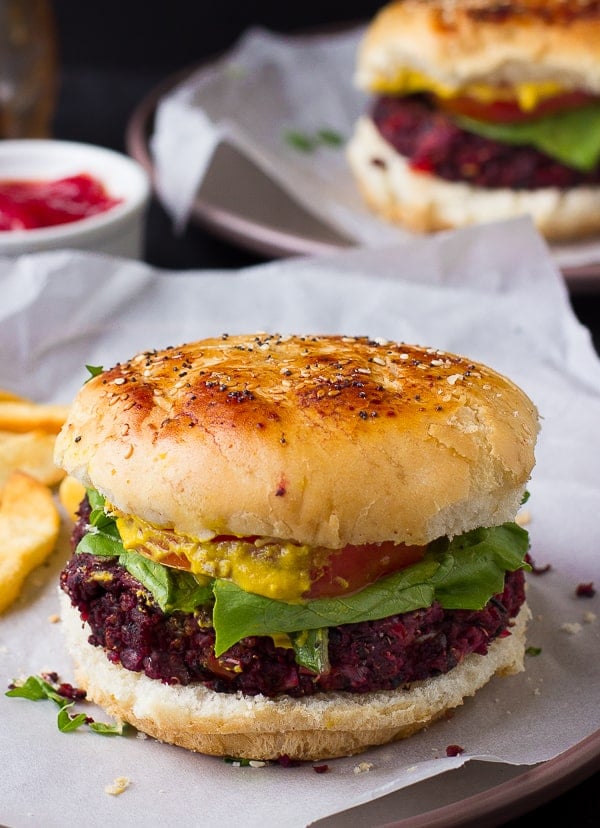 Side shot of vegan quinoa beet burgers on a parchment paper. 