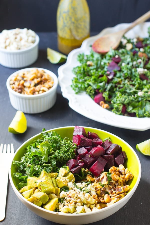 Roasted beet feta salad in a green bowl with a fork on the side. 