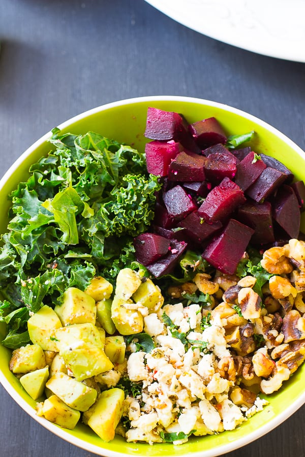 Overhead view of roasted beet salad in a green bowl. 