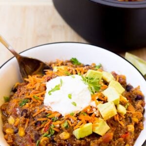 Slow Cooker Sweet Potato, Quinoa and Black Bean Chili in a bowl with a spoon.