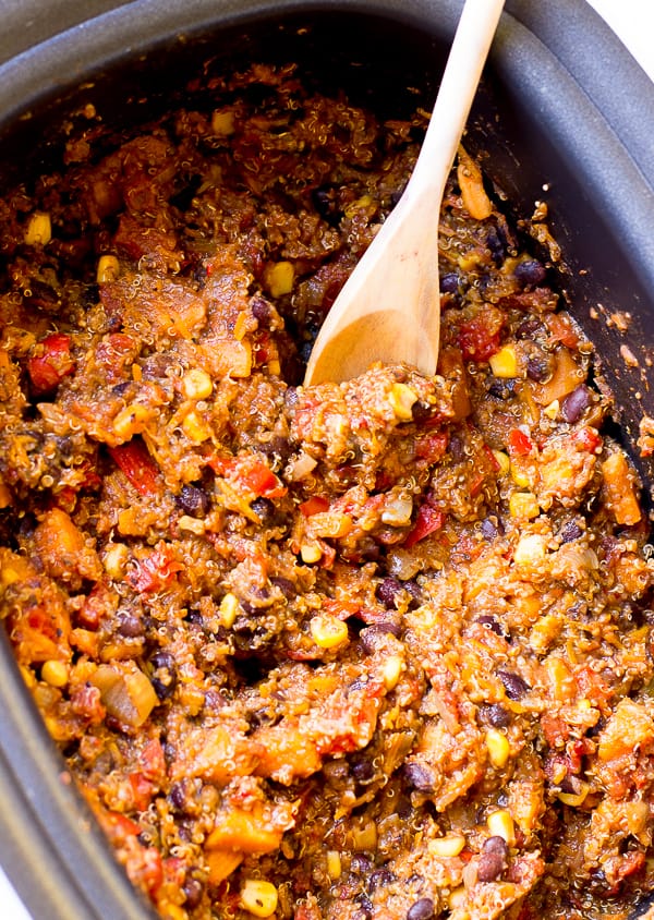 Top down view of sweet potato and quinoa chili, being stirred in a pot. 