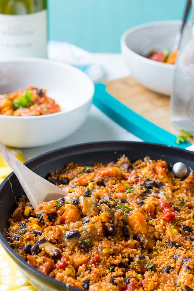 Side shot of a quinoa skillet with wooden spoon.