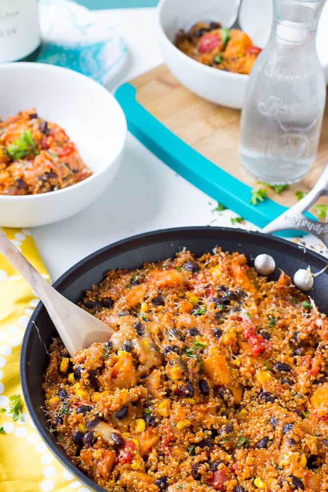 Quinoa enchilada skillet being stirred in a black pan. 