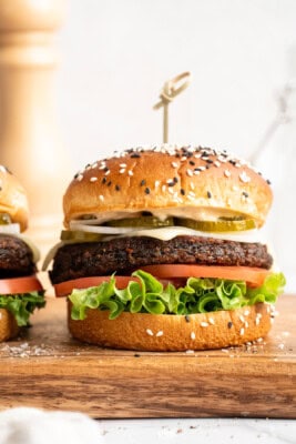 Beet burger with lettuce, tomato, vegan cheese, and pickles.