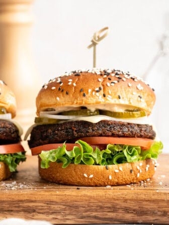 Beet burger with lettuce, tomato, vegan cheese, and pickles.