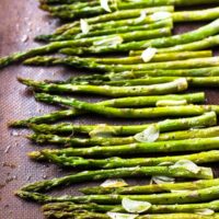 Top down shot of garlic roasted asparagus on a baking sheet.