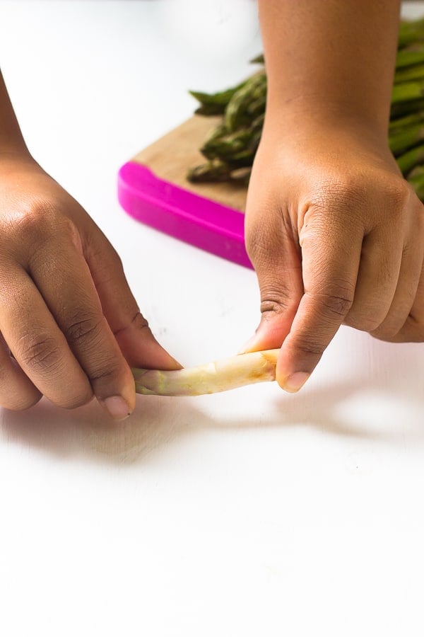 Hands snapping asparagus. 