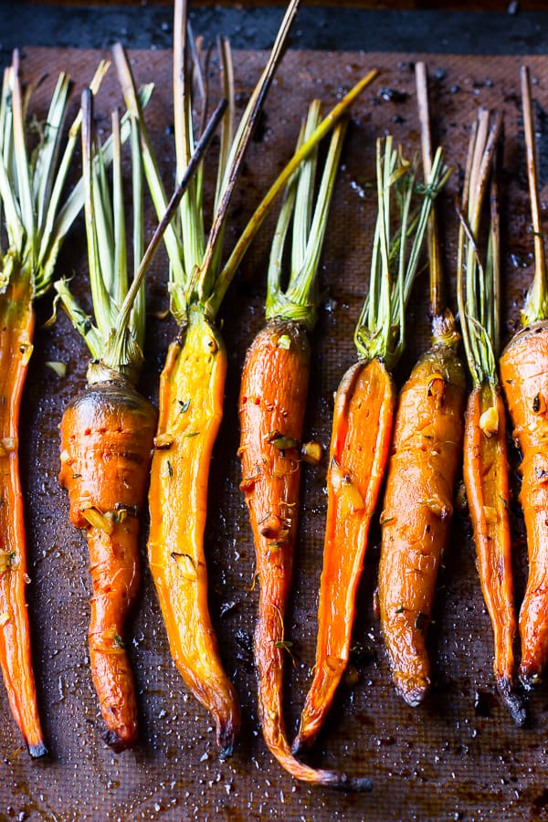 Top down shot of maple garlic roasted carrots on a baking sheet. 