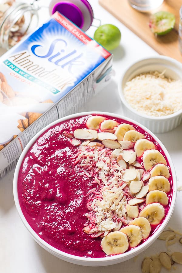 Banana berry beet smoothie bowl on a white table. 