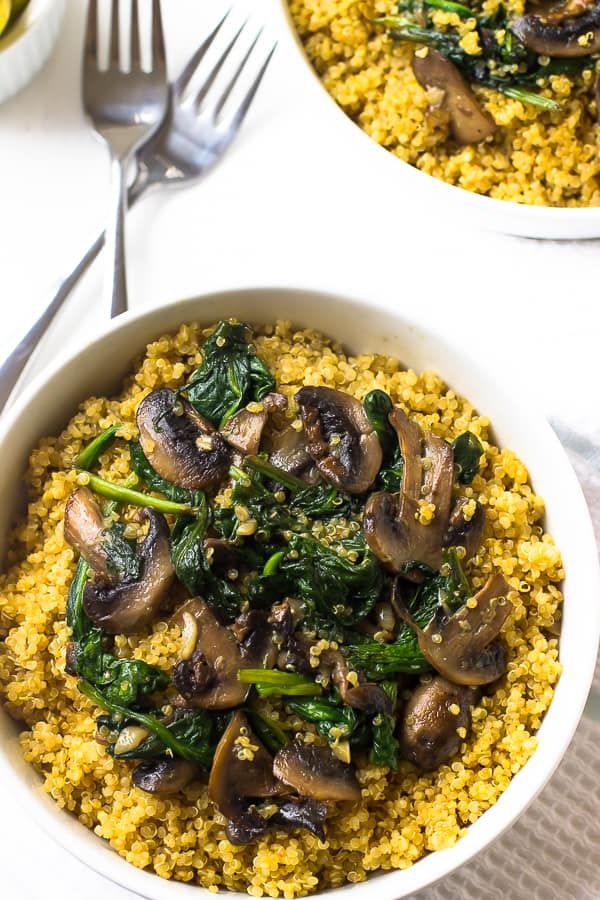 Overhead shot of creamy coconut spinach and mushroom quinoa in a white bowl. 