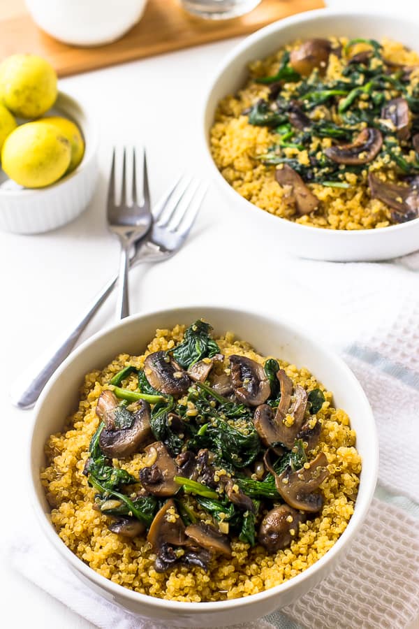 Two bowls of creamy coconut spinach and mushroom quinoa.