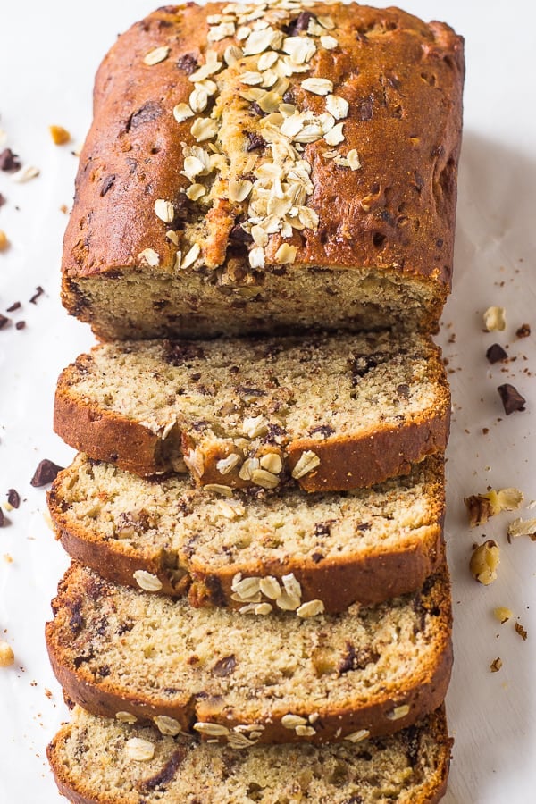 Overhead shot of sliced banana bread on a white table top.