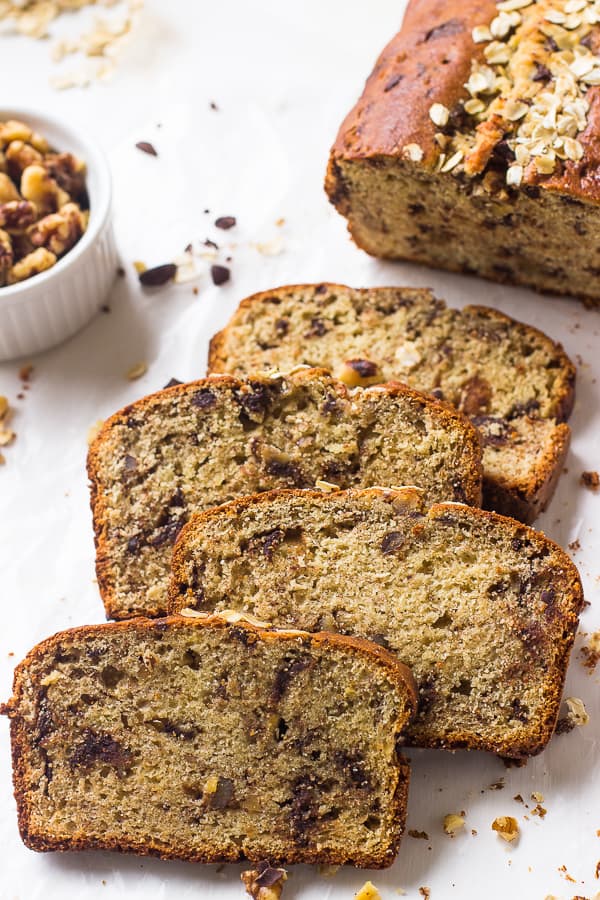 Slices of easy gluten free banana bread  next to a bowl of nuts.