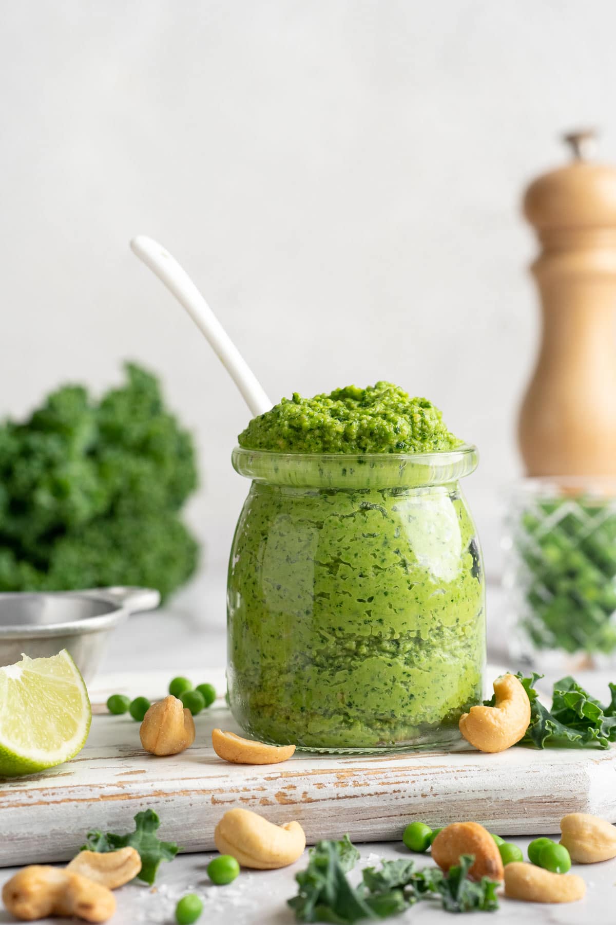 Jar of cashew pea pesto with spoon.