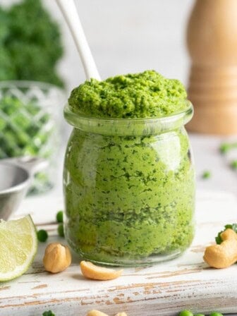 Spoon in jar of cashew pea pesto.