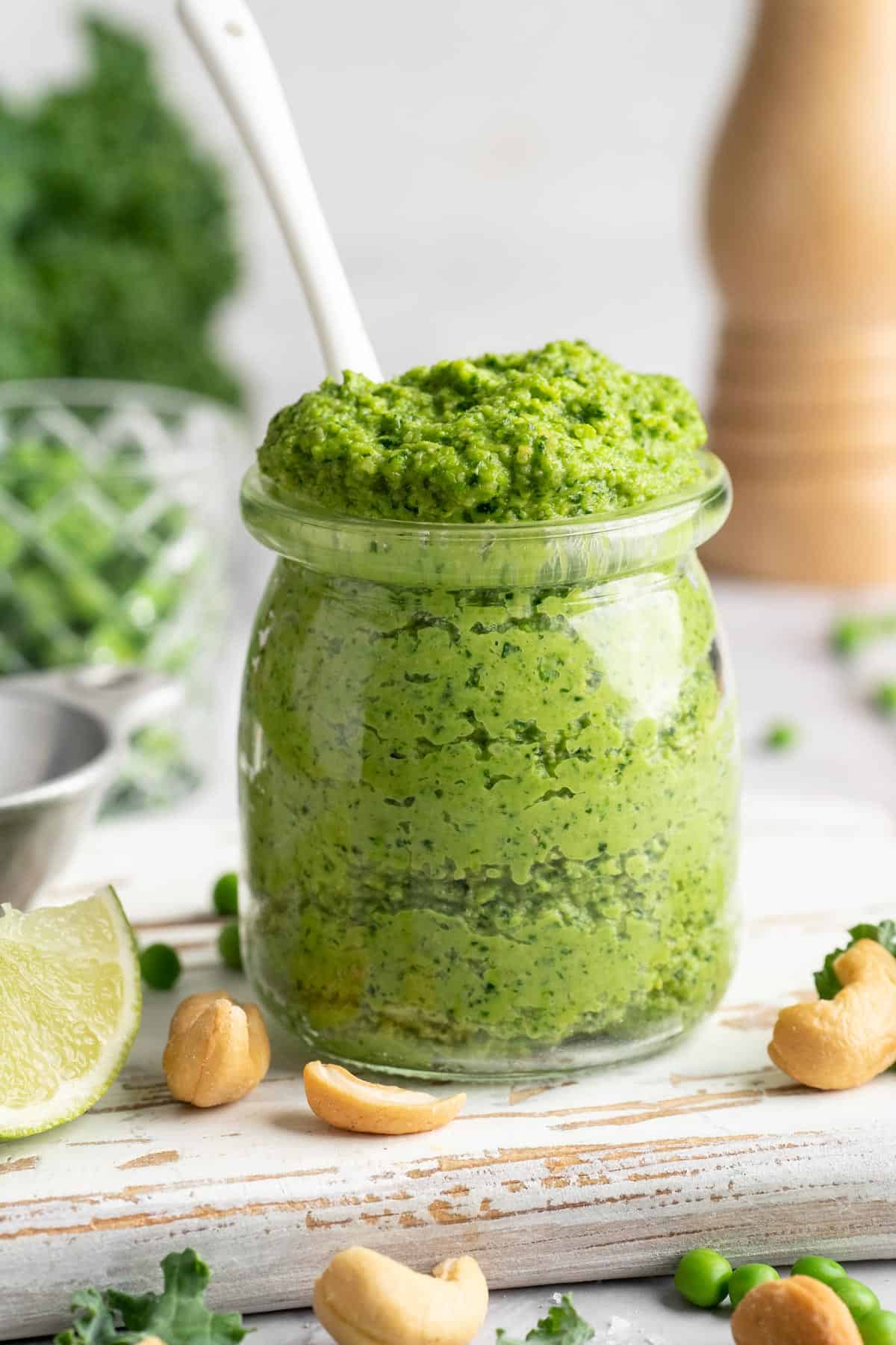 Spoon in jar of cashew pea pesto.
