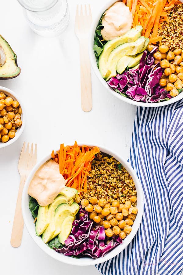 Top down shot of buddha bowls with wood spoons on the side. 