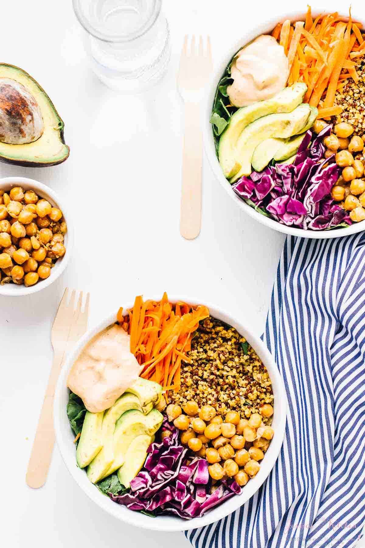 Overhead shot of two nourish buddha bowls on a white table. 