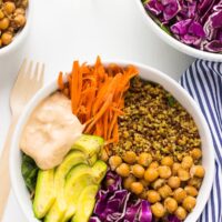 Two nourish buddha bowls on a white table.